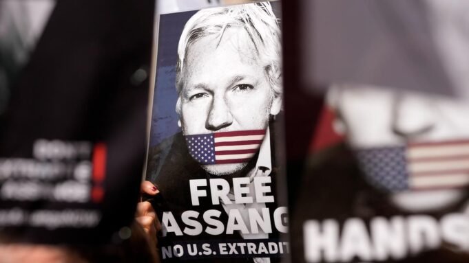 Ein Plakat mit dem Gesicht von Julian Assange.