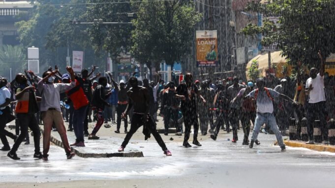 Demonstranten reagieren, als die Polizei bei einem Protest gegen geplante Steuererhöhungen in Nairobi, Kenia, am 25. Juni 2024 einen Wasserwerfer einsetzt und Tränengas abfeuert.