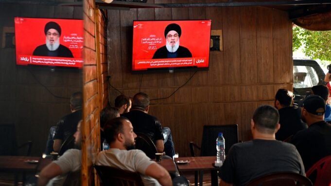 Menschen verfolgen eine im Fernsehen übertragene Rede von Hisbollah-Generalsekretär Hassan Nasrallah in einem Café in einem südlichen Vorort von Beirut.