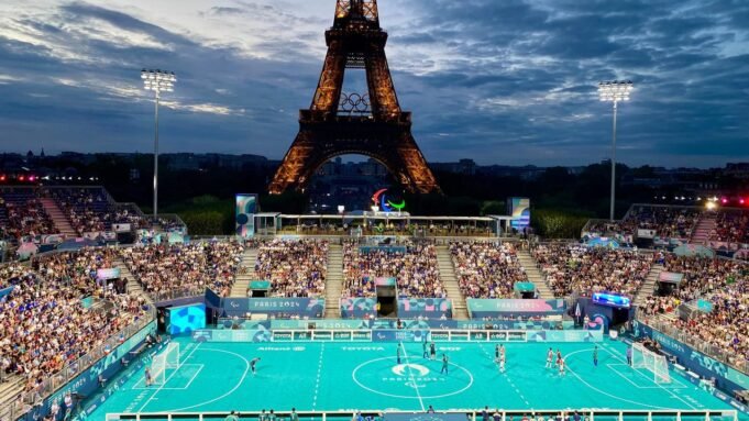 Vor dem Eiffelturm in Paris wird bei den Paralympics 2024 Blindenfußball in einer vollen Arena ausgetragen.