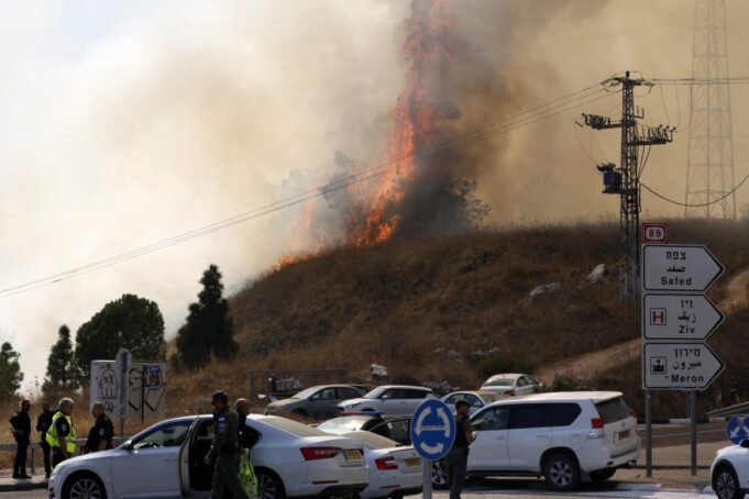 Israeli security forces and first reponder gather as a fire rages on a hill after rockets were fired from southern Lebanon, on the outskirts of Rosh Pinna in the Upper Galilee on October 20, 2024, amid the ongoing war between Israel and Hezbollah. (Photo by Jalaa MAREY / AFP) (Photo by JALAA MAREY/AFP via Getty Images)